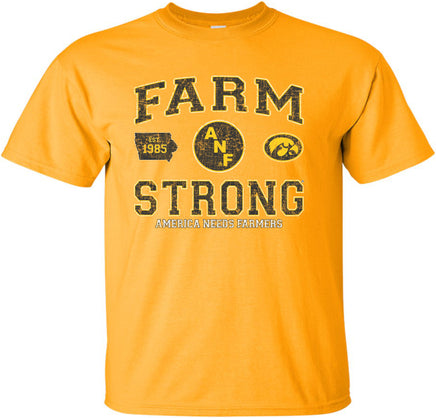 A gold short-sleeve t-shirt with a distressed black, white and gold design on the front that reads 'FARM STRONG' with 'AMERICA NEEDS FARMERS' underneath, alongside the ANF logo and the Iowa Hawkeyes Tigerhawk logo.